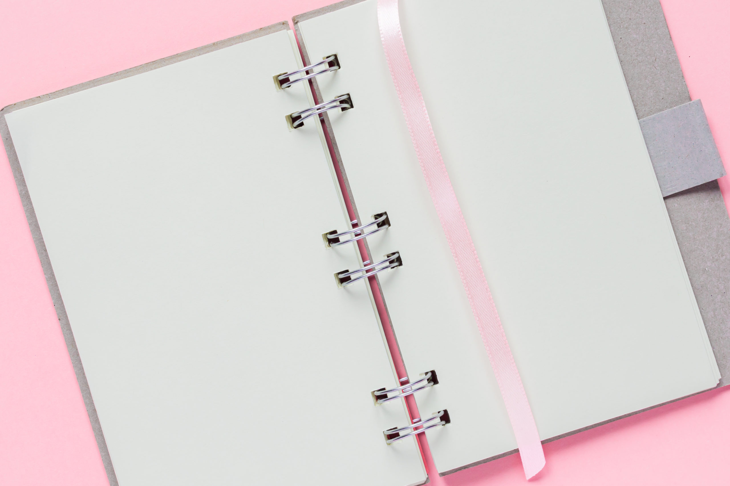 close up of open empty notebook with cover from recycled paper on pastel pink colorful background